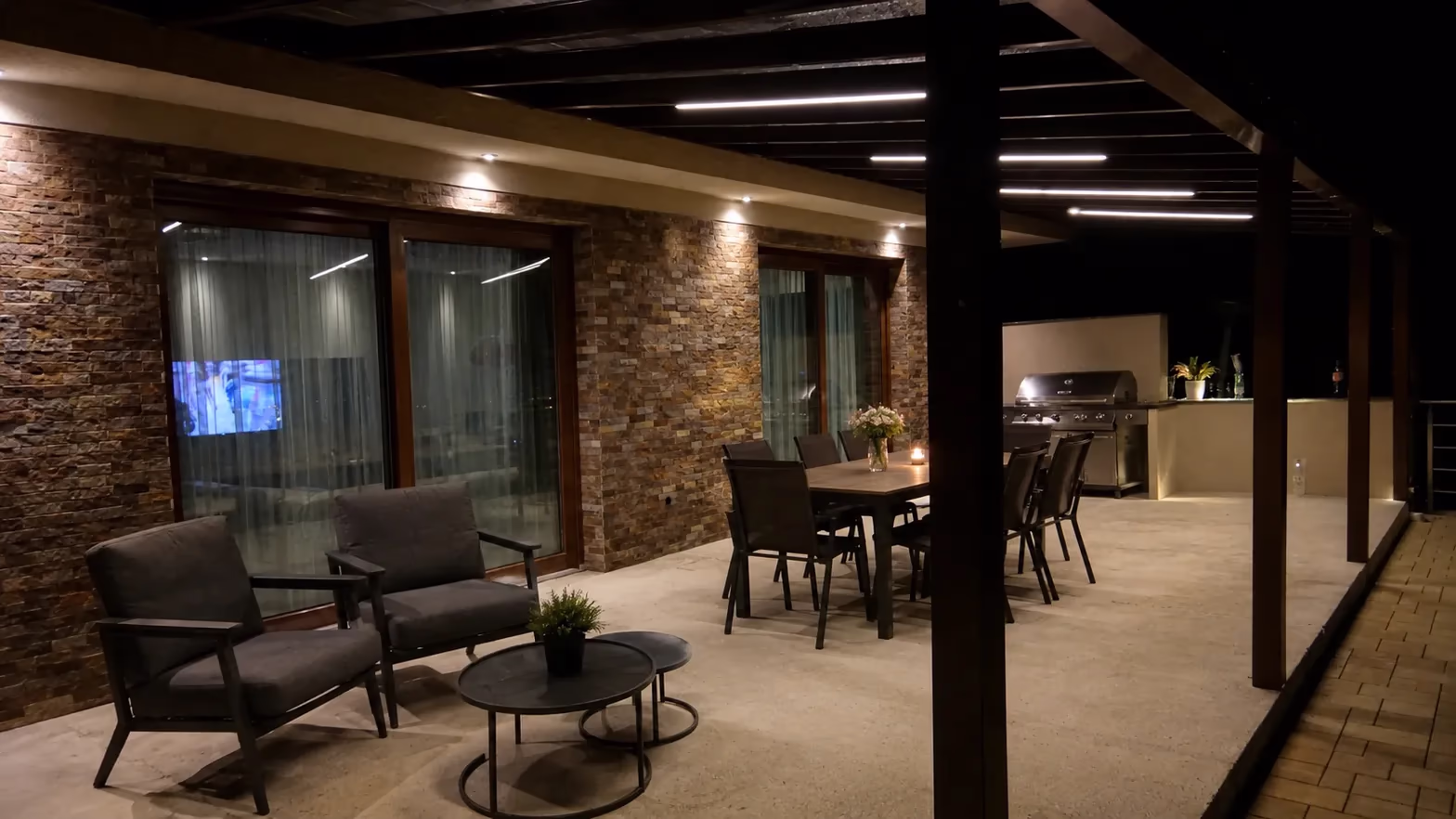 Drevená pergola s integrovaným LED pásikovým osvetlením nad nočnou terasou s jedálenským stolom
