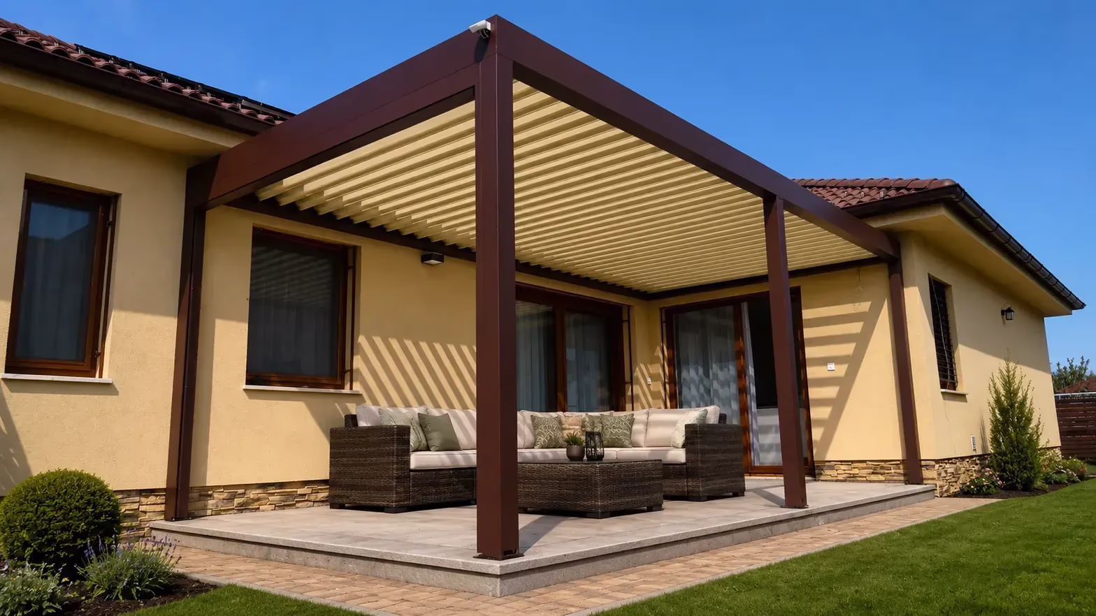 Hnedá bioklimatická pergola z odolného hliníka s uzavretými lamelami nad terasou