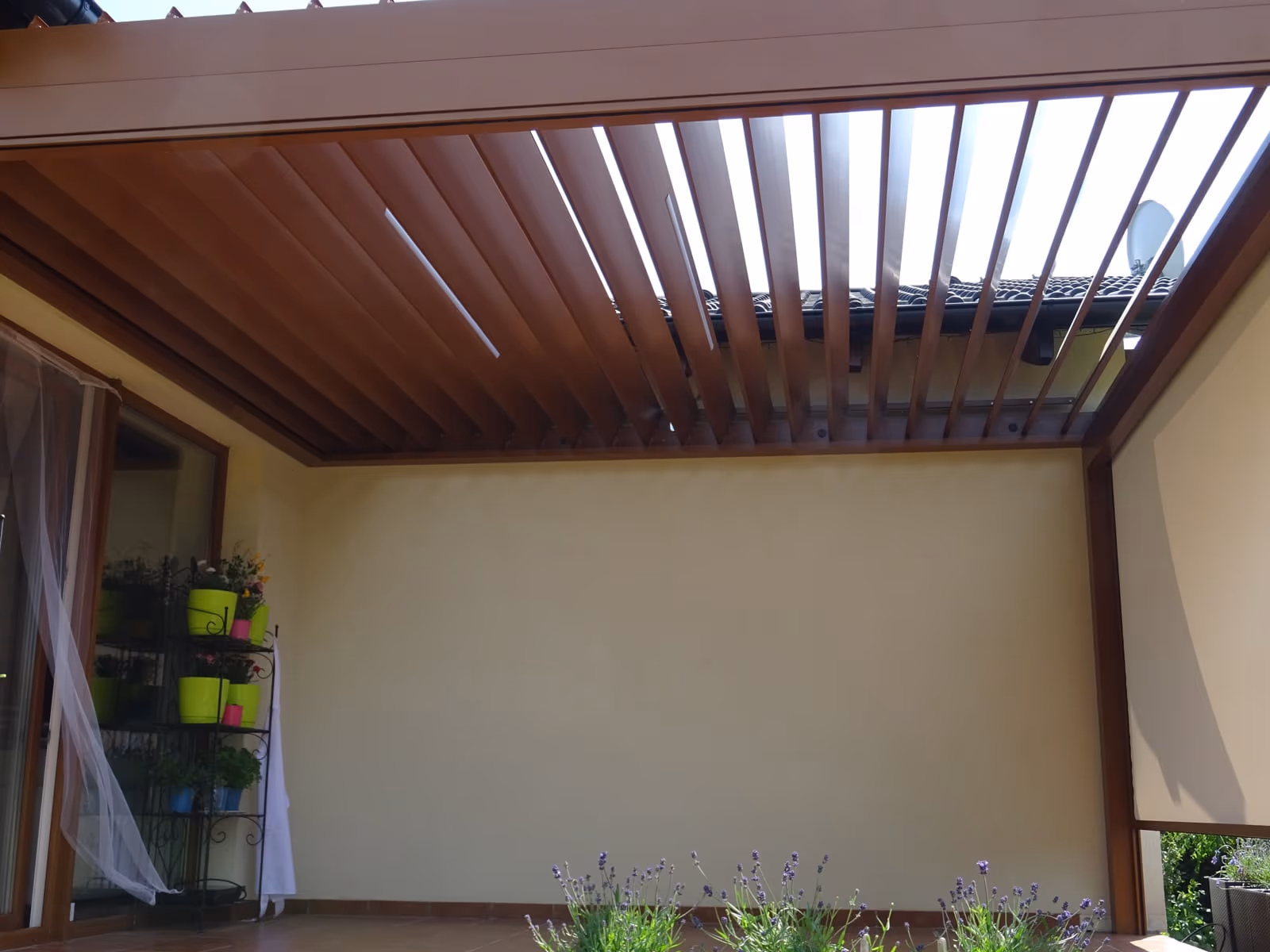 Bioklimatická hliníková pergola s natáčacími lamelami pri modernej novostavbe