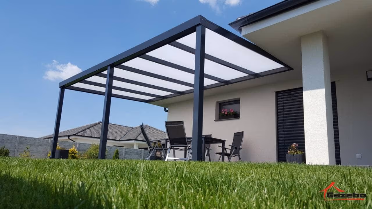 Antracitová hliníková pergola Economic Class pri bielom dome s posedením na terase a trávnikom