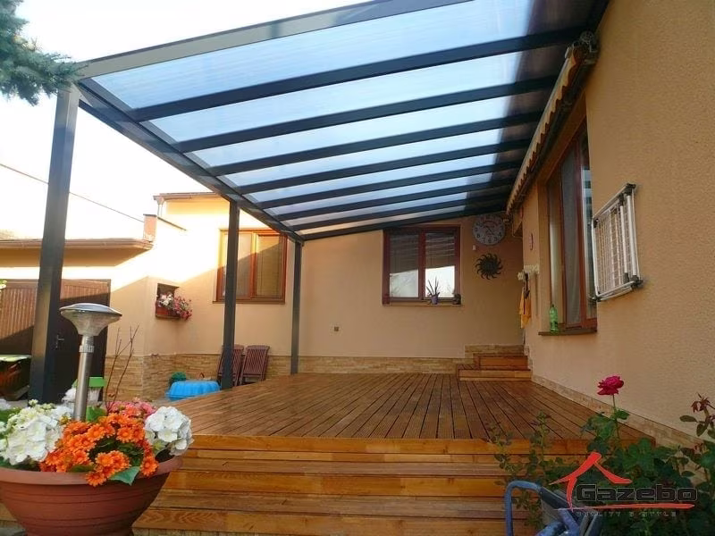 Antracitová hliníková pergola Economic Class nad drevenou terasou s ohrievačom a kvetmi