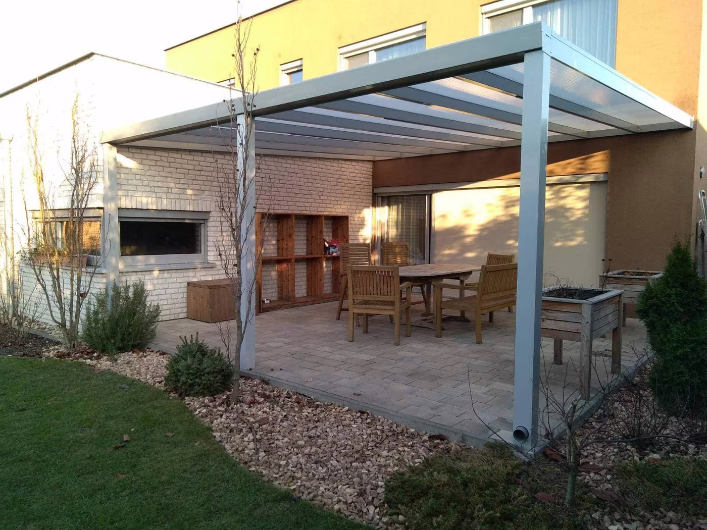 Strieborná hliníková pergola Economic Class nad štrkovou plochou s jedálenským sedením