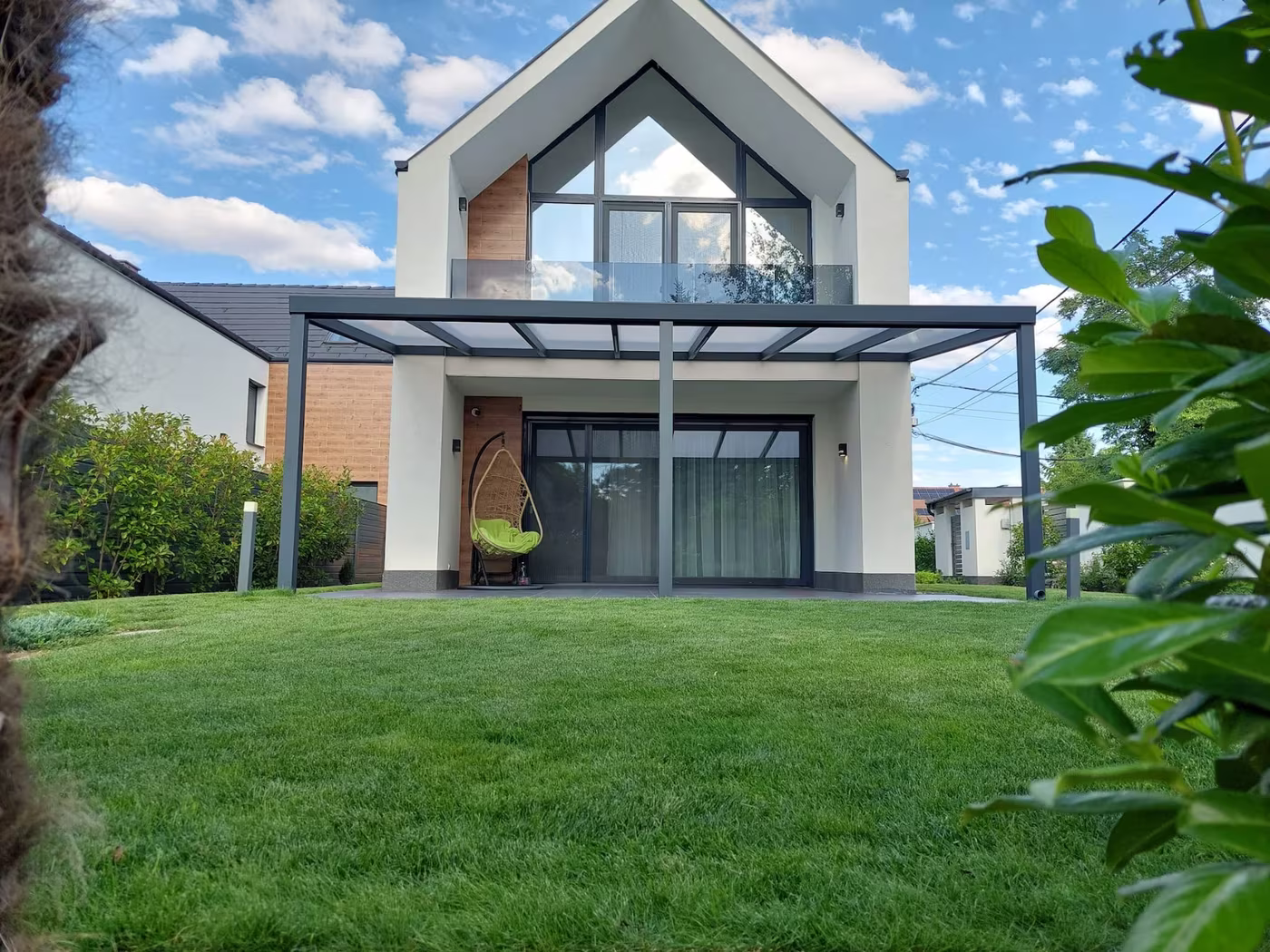 Antracitová hliníková pergola Economic Class nad terasou moderného domu so sedlovou strechou