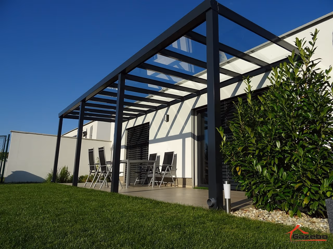 Hliníková pergola Top Class s jedálenským posedením pri bielom dome