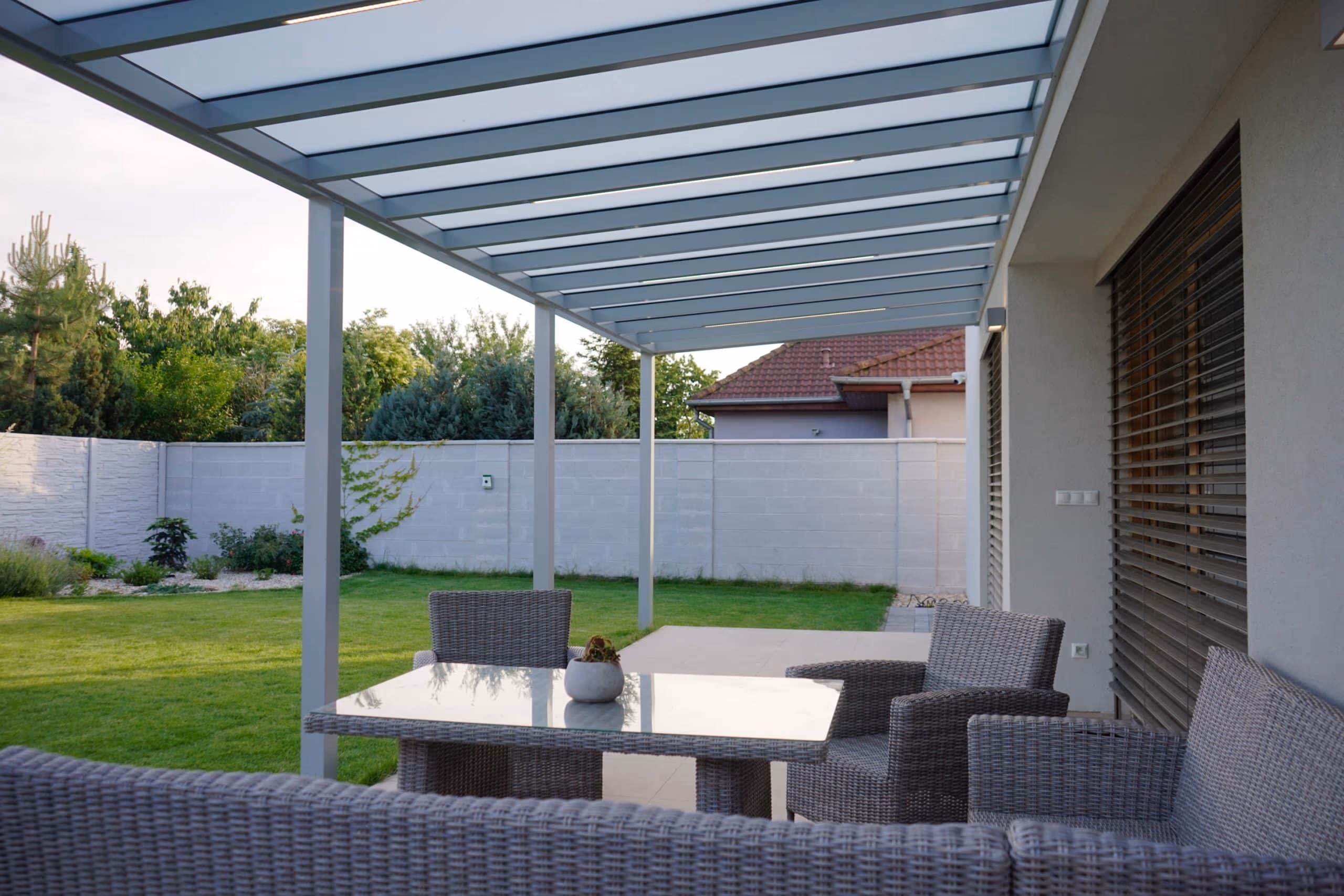 Hliníková pergola Top Class pri dome s drevenou fasádou