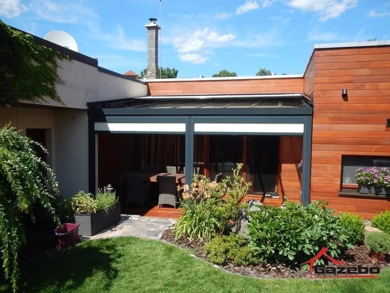 Antracitová hliníková pergola Top Class nad terasou so sedením pri dome s dreveným obkladom