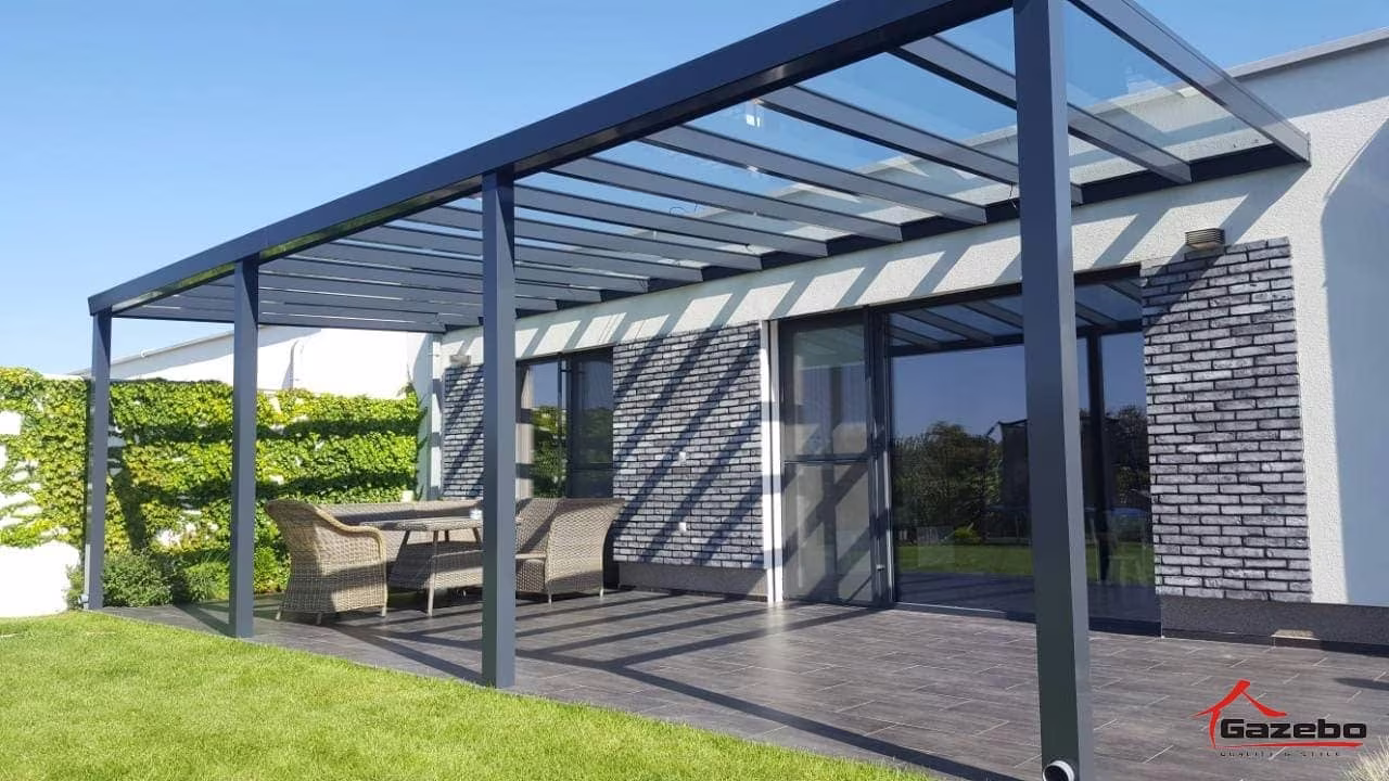 Antracitová hliníková pergola Top Class nad drevenou terasou s ratanovým sedením pri modernom dome
