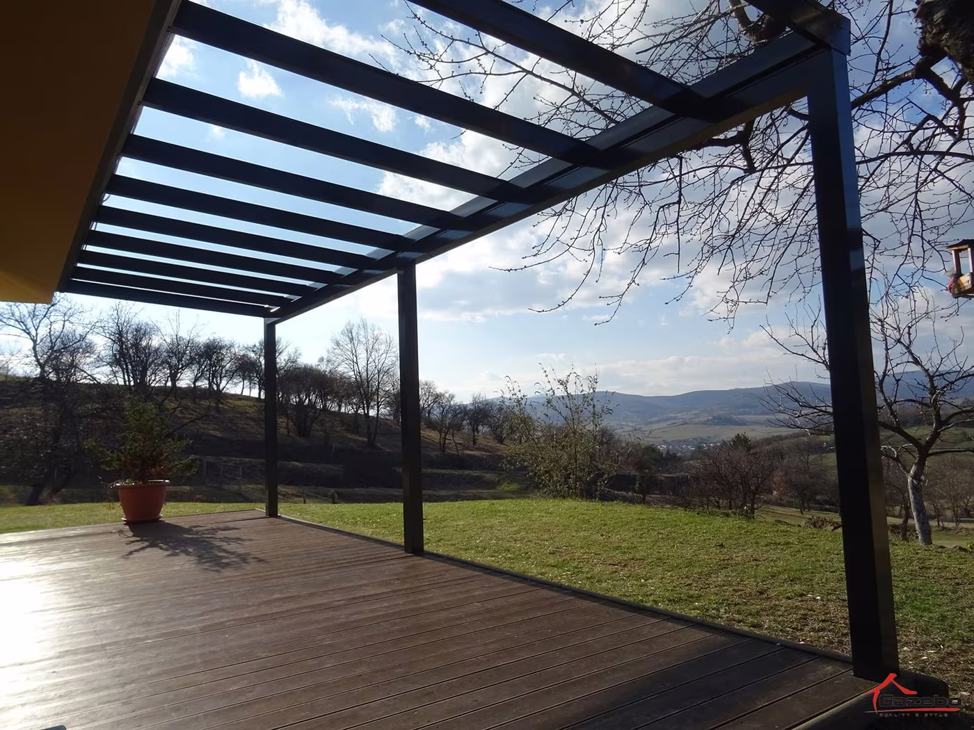 Antracitová hliníková pergola Top Class nad drevenou terasou s výhľadom do krajiny