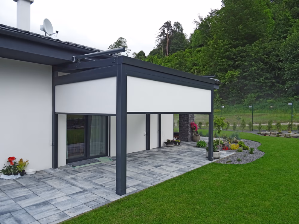 Hliníková pergola Top Class s čelnou elektrickou rolovacou clonou (tienením) pri dome