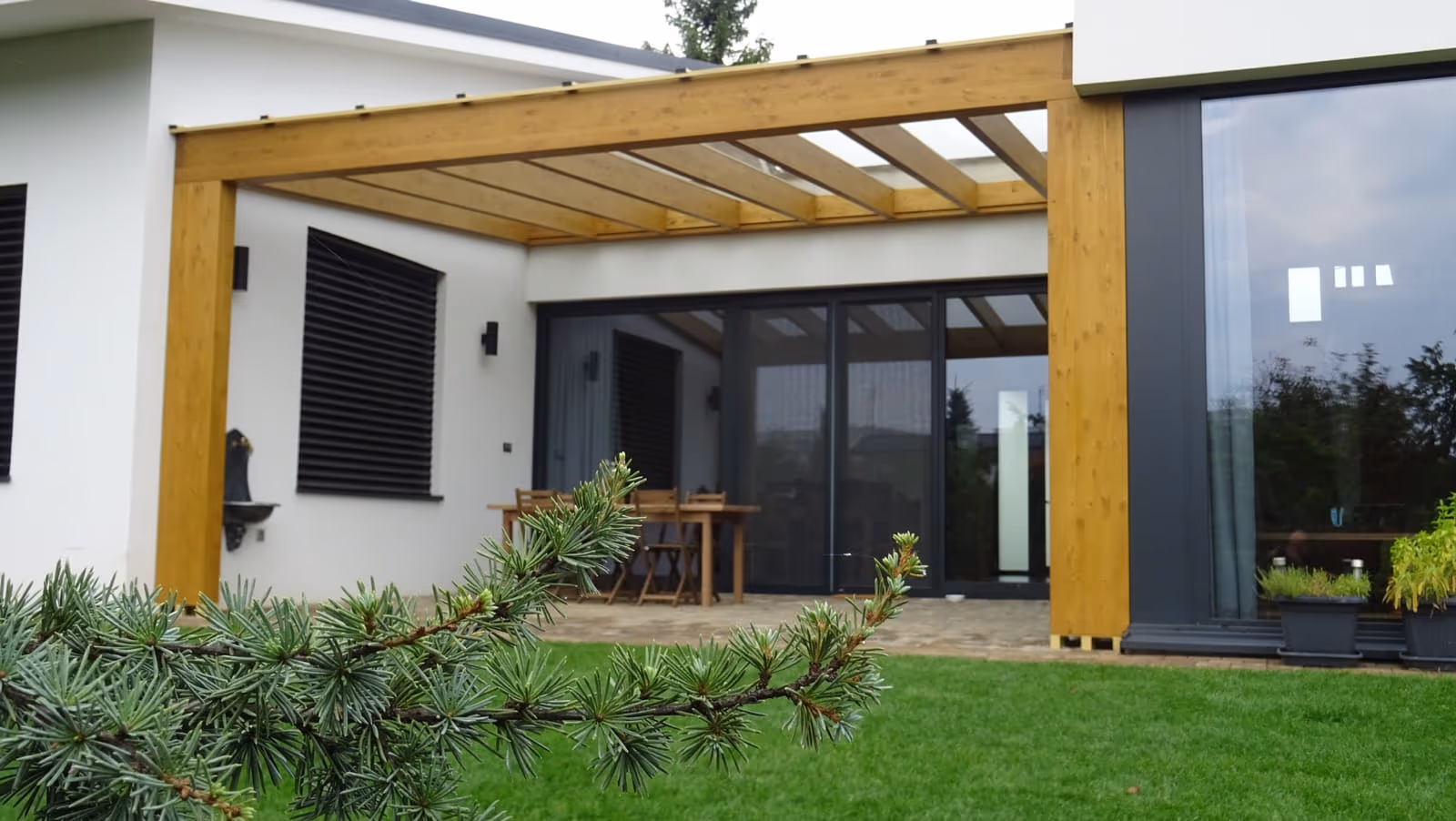 Drevená pergola Milano so svetlým drevom nad jedálenským posedením