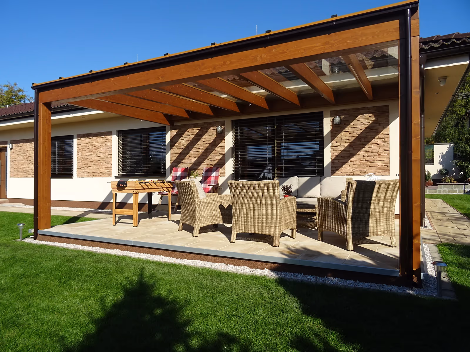 Drevená pergola Milano s jedálenským posedením pri kamennom dome
