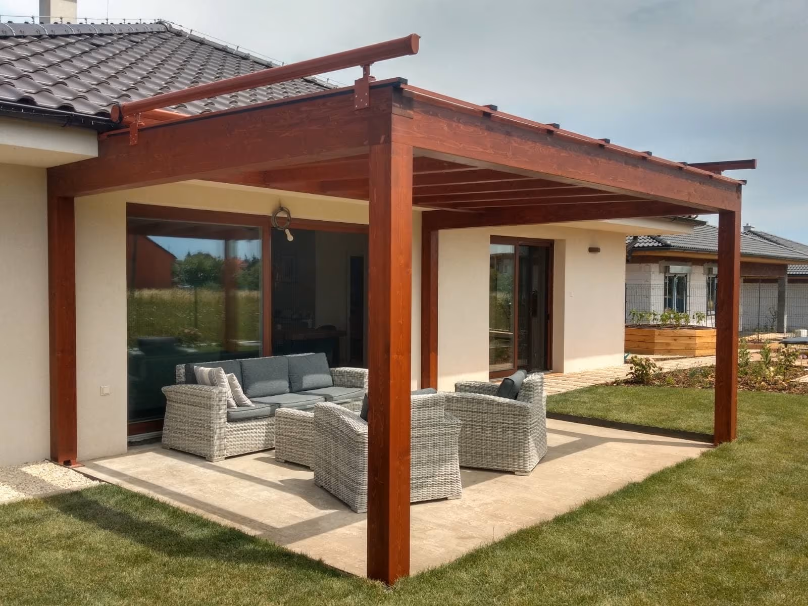 Drevená pergola Milano s ratanovým sedením v záhrade