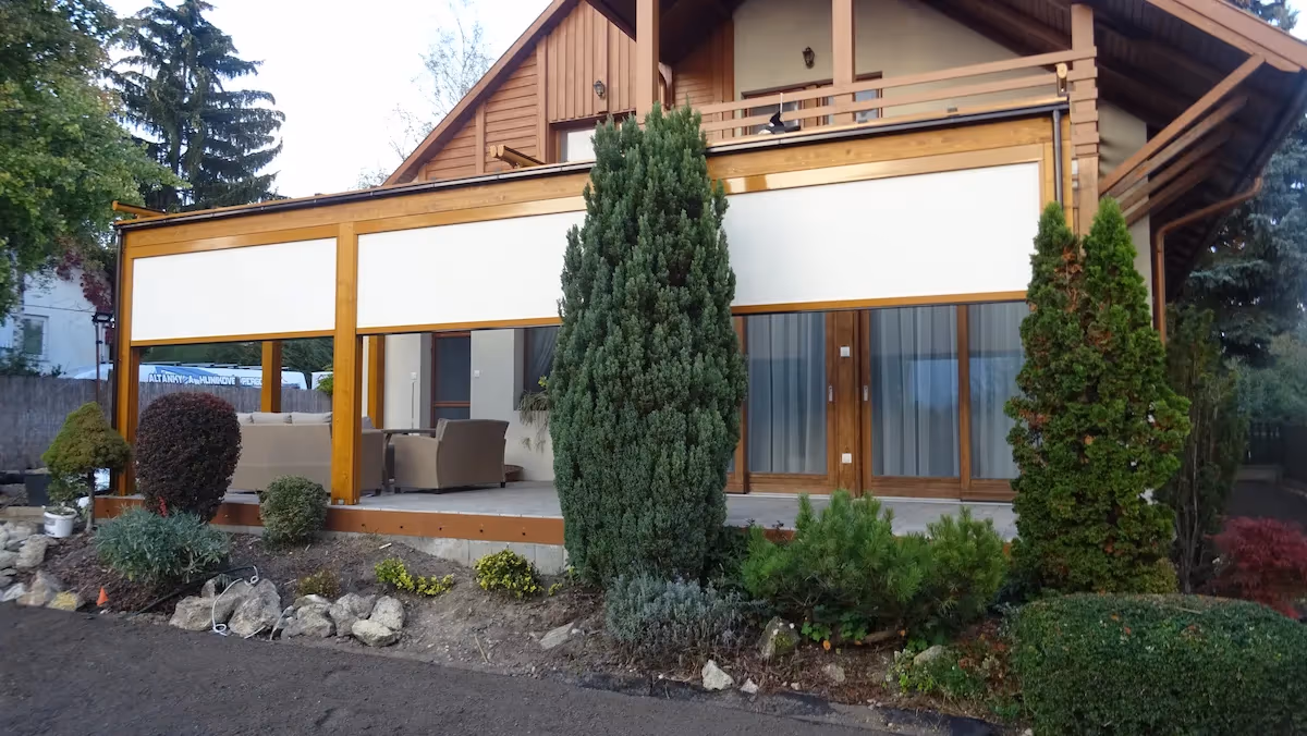 Drevená pergola Milano medzi ihličnatými stromami na terase
