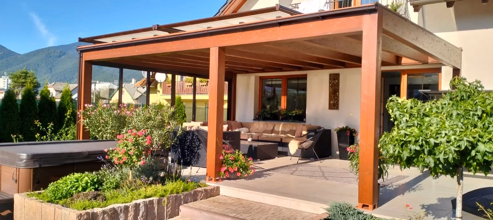 Drevená pergola Milano so sedačkou pri tmavom rodinnom dome