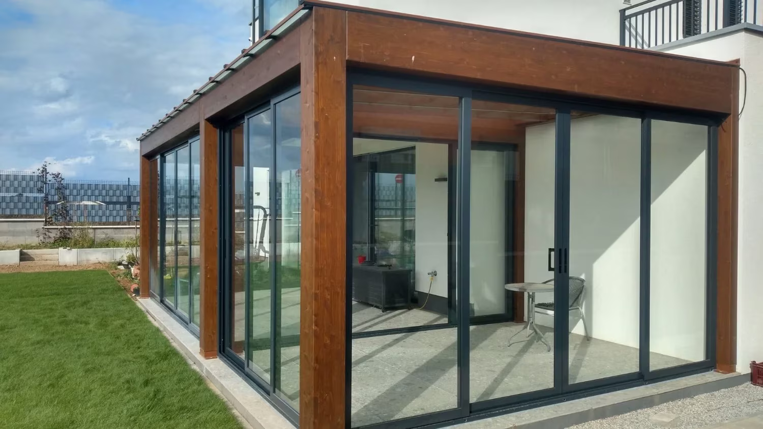 Presklená drevená pergola Milano ako obytný priestor pri dome