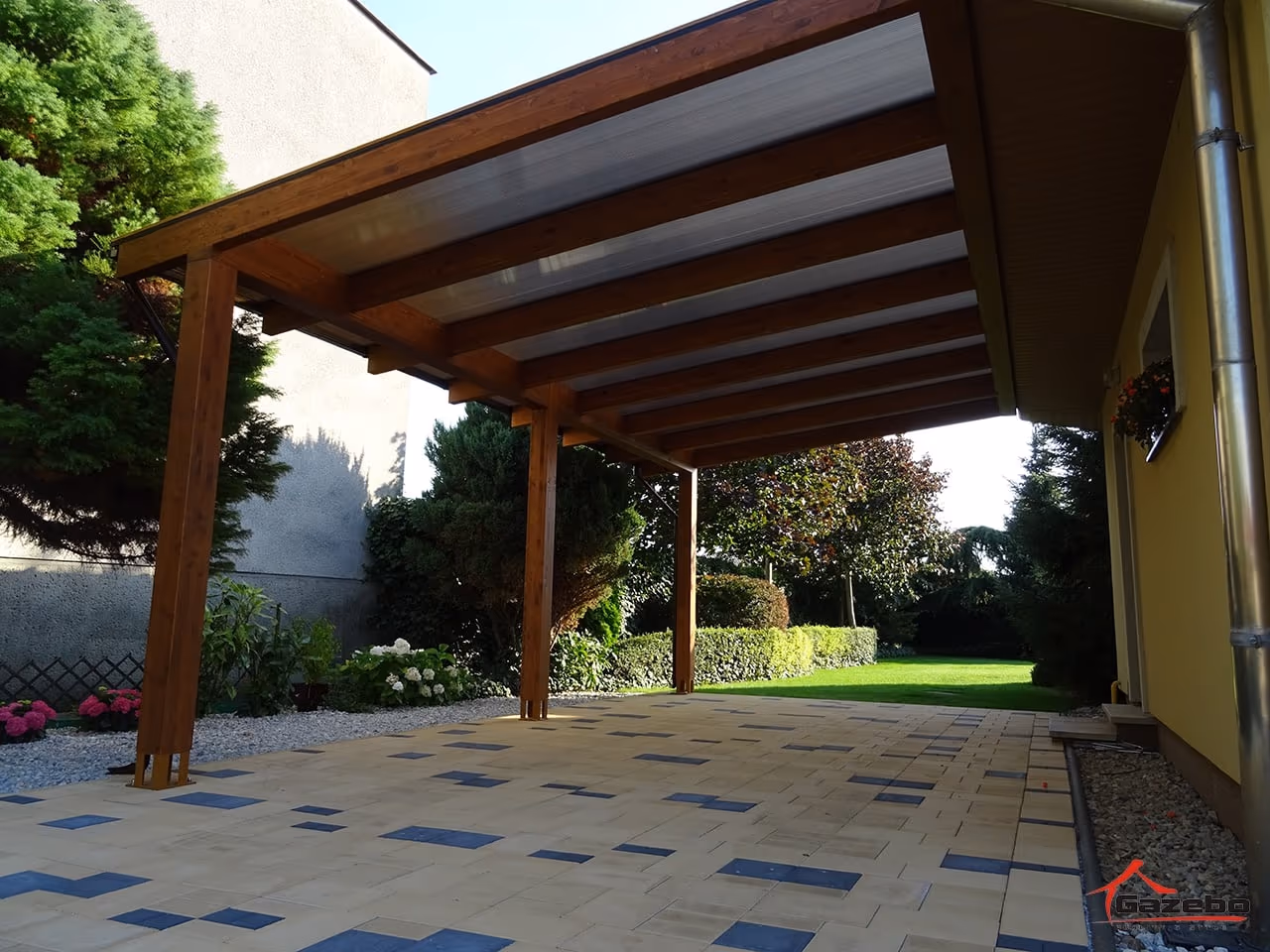 Drevená pergola Fénix nad terasou pri rodinnom dome s tehlovou strechou
